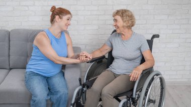 Hamile kızıyla tekerlekli sandalyedeki yaşlı kadın.