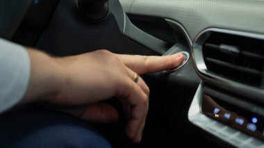 Bir adam motoru çalıştırma düğmesine basar