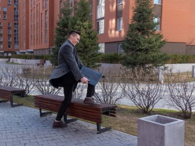 Kafkasyalı adam çıldırdı ve dışarıda dizüstü bilgisayar kırdı.