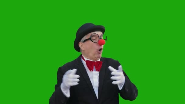 Een Oudere Man Een Clownspak Lacht Tegen Een Groene Achtergrond — Stockvideo