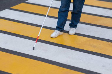 Yaya geçidinden sopayla geçen kör bir kadının bacaklarına yakın çekim.