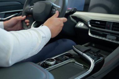 Modern bir arabanın direksiyonundaki adamın yakın çekimi.