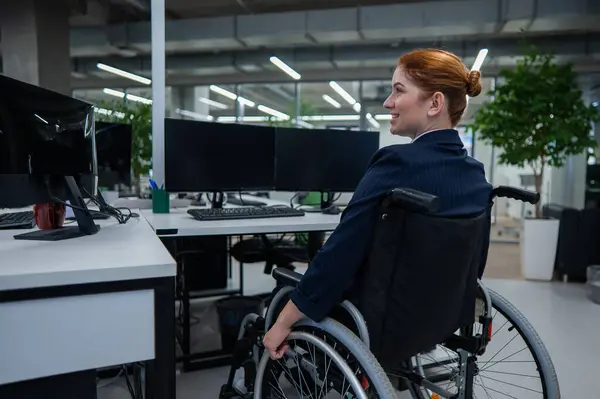 Caucasian woman in wheelchair at work desk