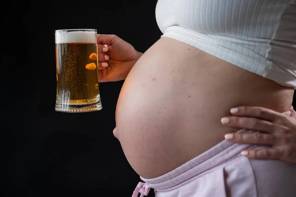 Close Barriga Uma Mulher Grávida Segurando Copo Cerveja Fundo Preto — Fotografia de Stock