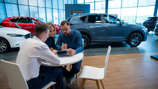 Szczęśliwa Kaukaska Para Podpisuje Kontrakt Zakup Salonu Samochodowego — Zdjęcie stockowe