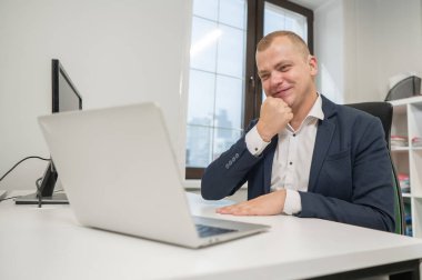 Kafkasyalı sağır adam ofiste dizüstü bilgisayardan işaret dili konuşuyor.