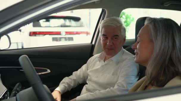 Starsza Para Wybiera Nowy Samochód Salonie Samochodowym Dojrzała Kobieta Prowadzi — Wideo stockowe