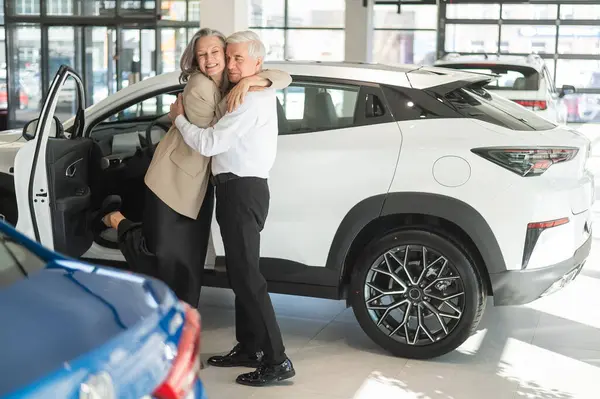 Dojrzałe Kaukaskie Przytulanie Się Starszy Mężczyzna Kobieta Kupują Nowy Samochód — Zdjęcie stockowe