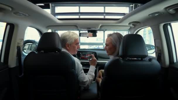 Una Pareja Ancianos Está Sentada Dentro Coche Nuevo Concesionario Automóviles — Vídeo de stock