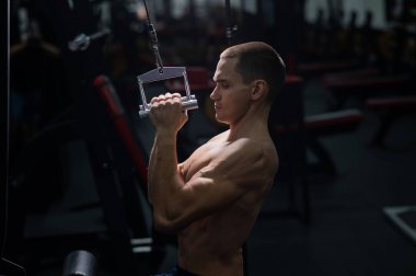 A man does a chest pulldown in the gym
