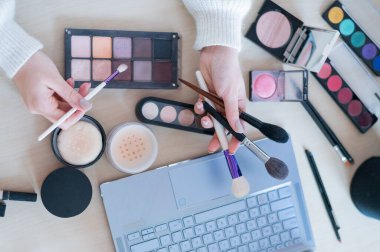 Yüzü olmayan bir kadın dizüstü bilgisayardaki profesyonel bir makyaj sanatçısından online eğitim izliyor. Uzaklık öğrenimi.