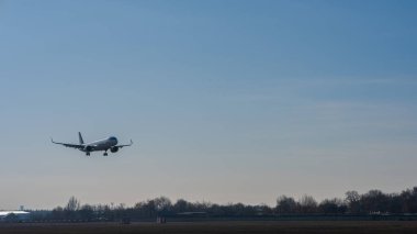 Mavi gökyüzüne karşı bir iniş uçağı görüntüsü