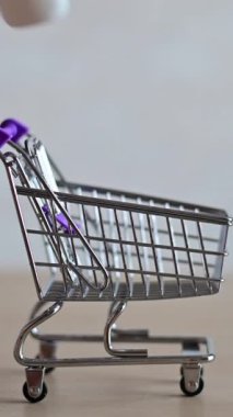 Fok balığındaki eczacı küçük bir alışveriş arabasını viral solunum hastalığı için çeşitli ilaçlarla dolduruyor. İlaç burun spreyi ve tramvayda bir tablet. Dikey video