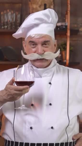 Ένας Ηλικιωμένος Σεφ Εκθρονίζει Κόκκινο Κρασί Στην Κουζίνα Κάθετη Βίντεο — Αρχείο Βίντεο