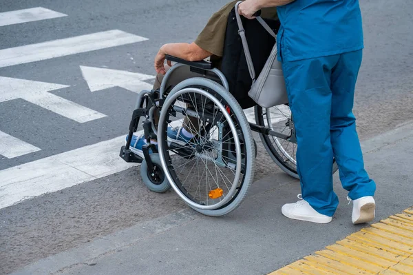 Tekerlekli Sandalyedeki Yaşlı Bir Kadının Karşıdan Karşıya Geçmesine Yardım Eden — Stok fotoğraf