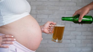 Hamile kadın için bira dolduran adam