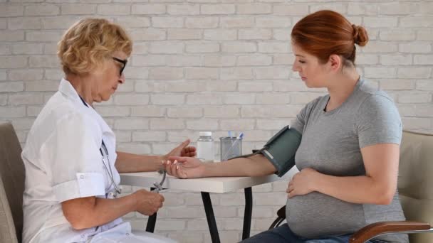 医師は妊婦の圧力を測定する — ストック動画