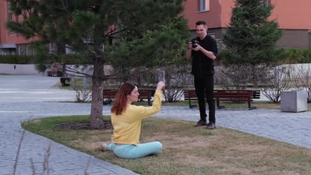 Wanita Kaukasia Berpose Sambil Duduk Rumput Seorang Pria Mengambil Foto — Stok Video