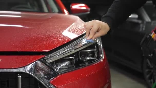 Майстер Застосовує Вінілову Плівку Фари Червоного Автомобіля — стокове відео