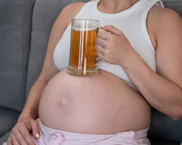 Uma Mulher Grávida Sem Rosto Senta Sofá Segura Copo Cerveja — Fotografia de Stock