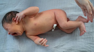 Yeni doğmuş küçük bir çocuk ağlıyor. Bir kadın 1 haftalık oğlunu sakinleştirmeye çalışır.