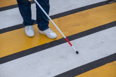 Yaya geçidinden sopayla geçen kör bir kadının bacaklarına yakın çekim.