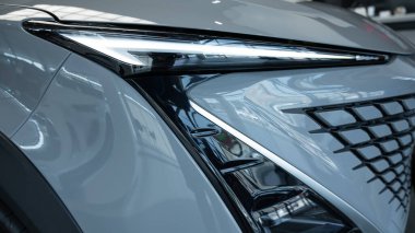 Beyaz, modern bir arabanın farına yakın çekim.