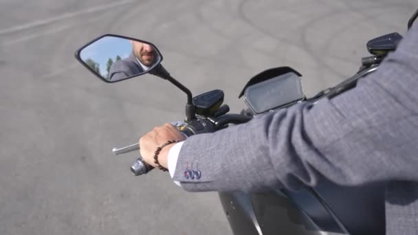 一个穿夹克的男人坐在桥下的电动摩托车上 收回相机 — 图库视频影像