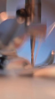 Dikiş dikme işlemi sırasında dikiş makinesinin iğnesinin yakın çekimi. Dikey video