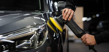 A master polishes the surface of a car body clipart