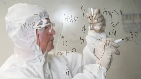 Elderly Caucasian Male Chemist Protective Suit Looks Test Tube Writes — Stock Photo, Image