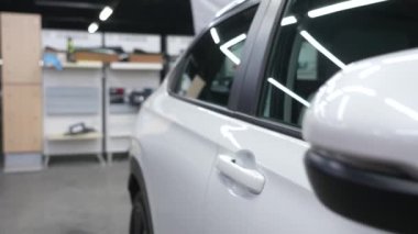 Kamera bir araba galerisindeki arabanın gövdesi boyunca süzülür.