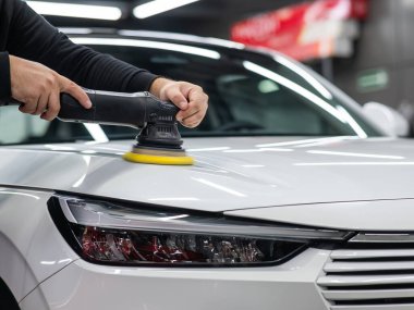 Yörüngesel cilalama makinesi kullanılarak beyaz arabanın kaput yüzeyinin parlatılması işlemi