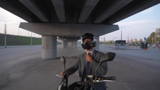Ceketli Kasklı Bir Adam Köprünün Altındaki Elektrikli Bir Motosiklette Oturuyor — Stok video