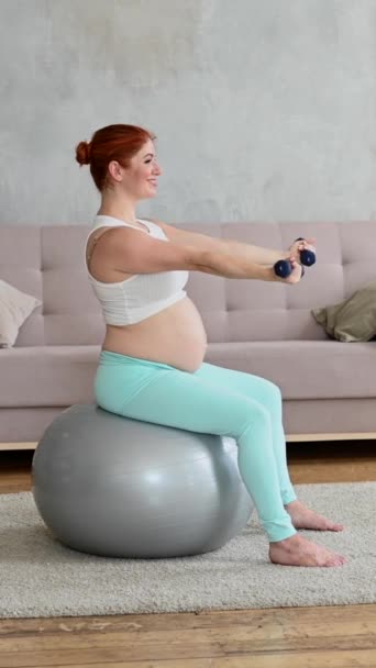 Gravid Kvinna Som Tränar Med Hantlar När Hon Sitter Fitnessboll — Stockvideo