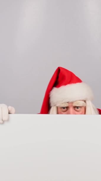 Santa Claus Dívá Zpoza Bílého Prkna Ukazuje Prstem Svislé Video — Stock video
