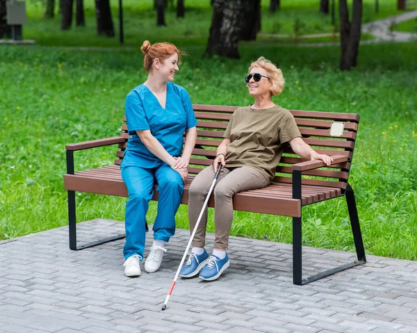 Una Enfermera Una Anciana Ciega Están Sentadas Banco Parque —  Fotos de Stock