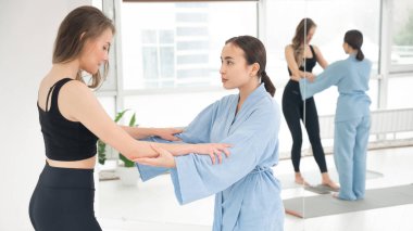 Kafkasyalı kadın terapist desteğiyle sadhu tahtasında duruyor.