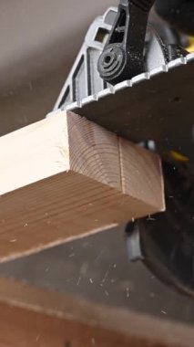Usta atölyede dairesel bir testere ile tahtayı keser. Dikey video