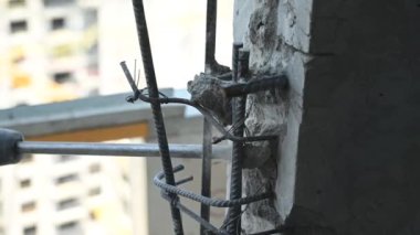 İnşaatçının biri inşaat alanında beton bir duvarı deliyor.