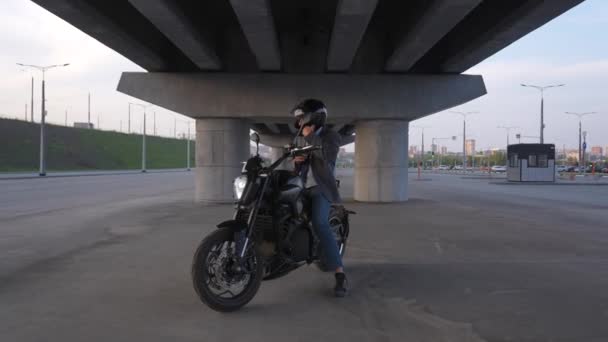 Muž Bundě Helmě Sedí Elektrické Motorce Pod Mostem Přiblížení Fotoaparátu — Stock video