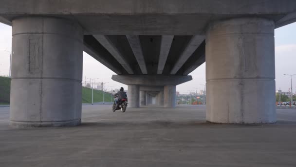 Muž Bundě Helmě Jezdí Elektrické Motorce Pod Mostem — Stock video