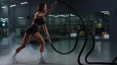 Beyaz kadın halatlarla egzersiz yapıyor. Spor salonunda tur eğitimi var. Yavaş çekim