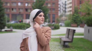 Açık havada tesettüre bürünmüş genç bir kadının portresi