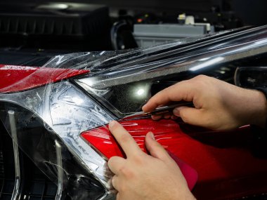 Detaylandırmada arabanın farlarına koruyucu vinil film uygulama süreci