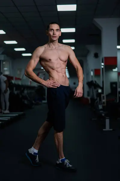 Shirtless man with sculpted body in the gym