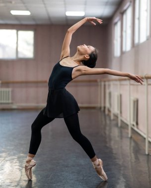 Asian woman dancing in ballet class. Bending in the back