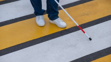 Yaya geçidinden sopayla geçen kör bir kadının bacaklarına yakın çekim.