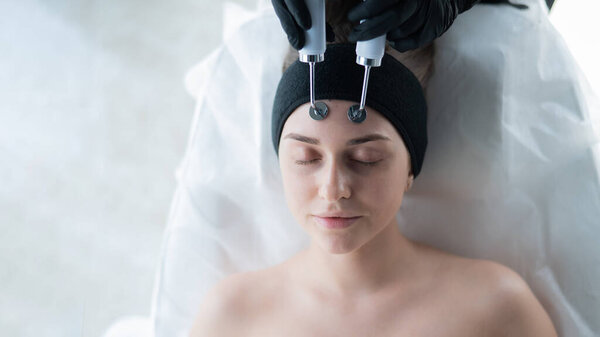 Молодая белая женщина на процедуре микротоковой терапии. Офис ботаника