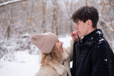 Genç bir çift kışın parkta yürür. Adam ve kız sokakta oynaşıyor.